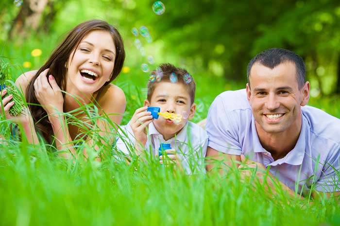 fotografia di una famiglia felice distesa su un prato